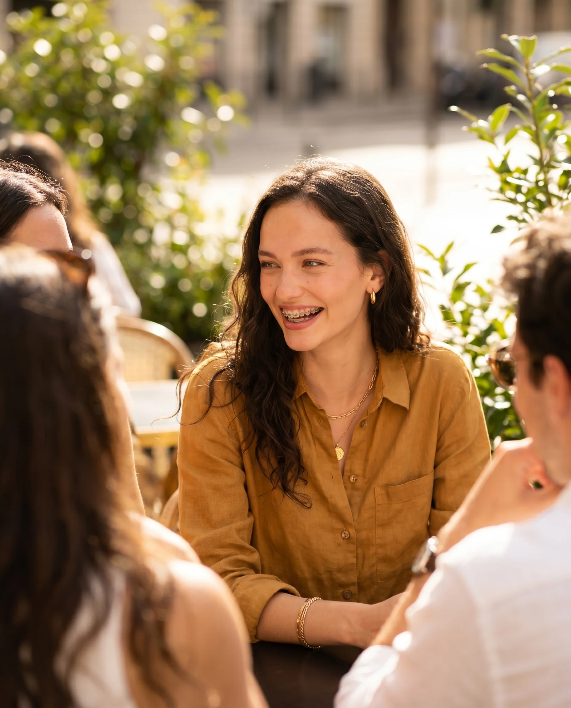 A person with braces smiling in warm natural light at seesmile